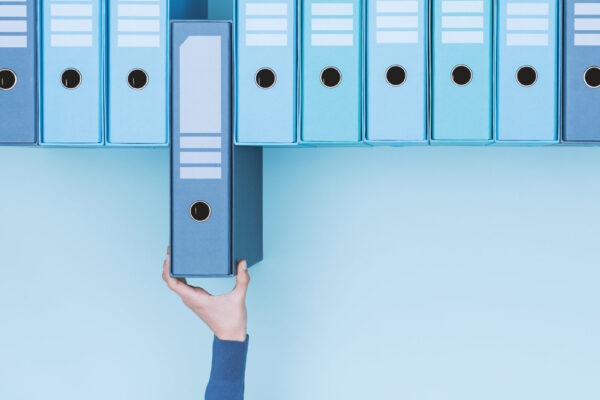 A hand reaching for an office box file.